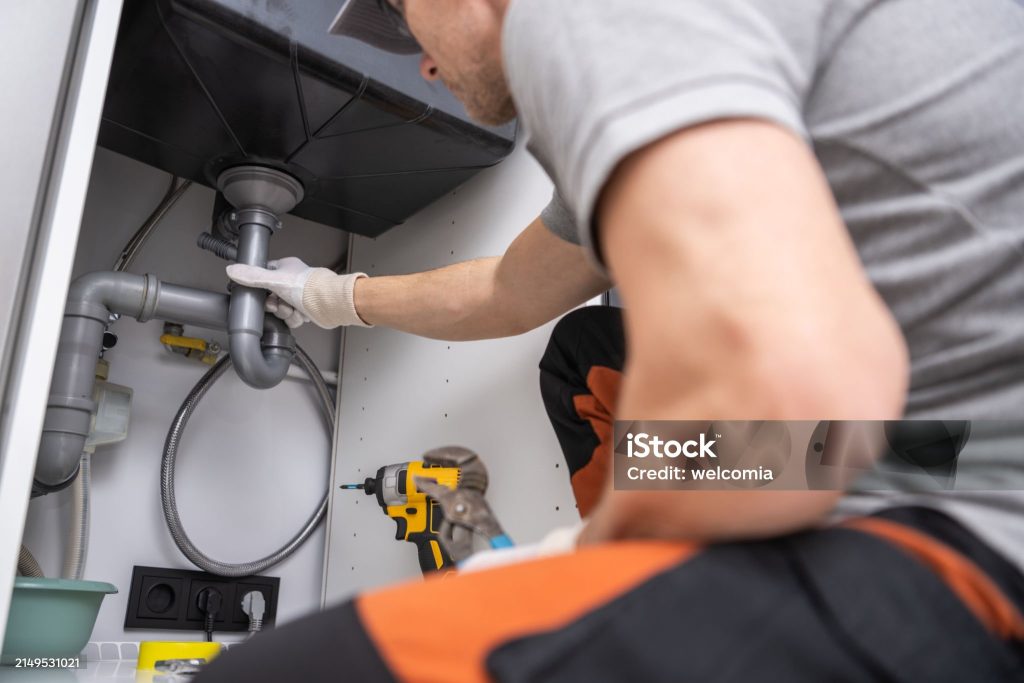 Caucasian Plumber Performing Quick Kitchen Sink Drain Fix